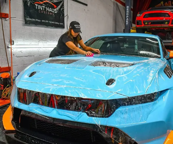 A front three-quarter view of a luxury car featuring a sleek matte color-change vinyl wrap