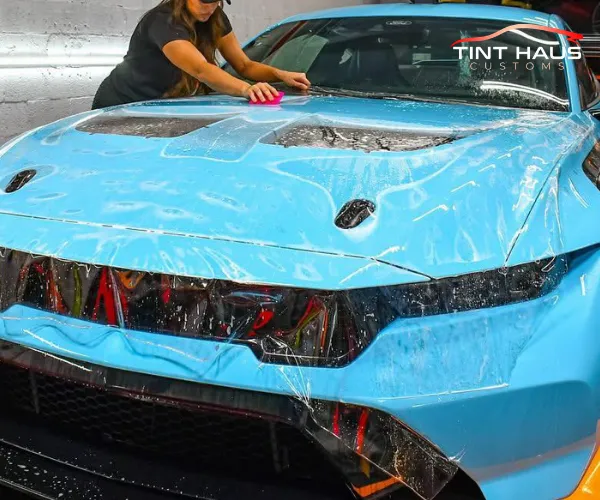 A side profile view of the wrapped luxury vehicle, highlighting the flawless application and smooth texture of the vinyl wrap